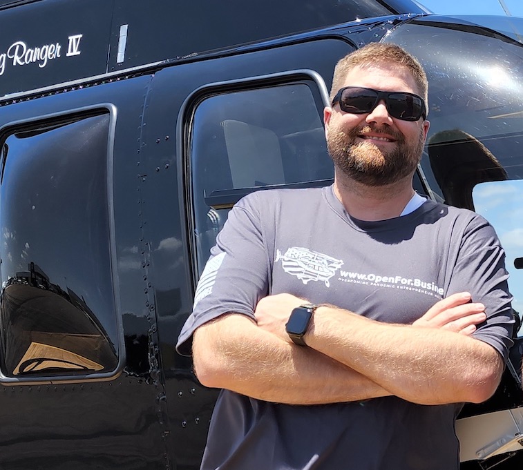 Profile photo of Steven next to Bell 206L4 helicopter